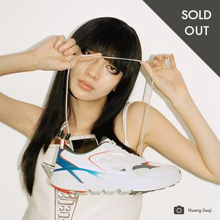 SOLD OUT Woman in a white tank top holding a shoe
