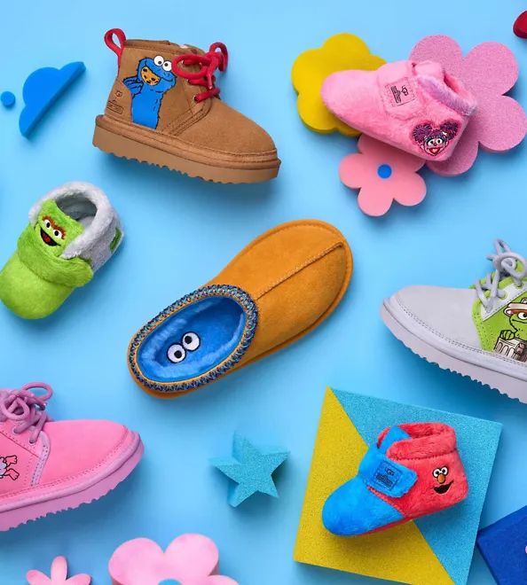 Several kids' shoes from the UGG and Sesame Street collection on a blue floor.