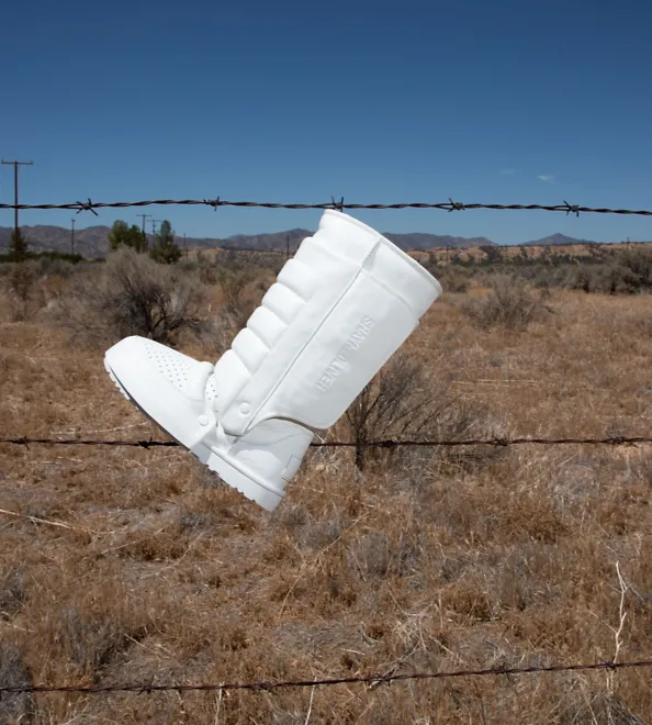 The Shayne Armourite Greaves on a barbwire fence in the desert.