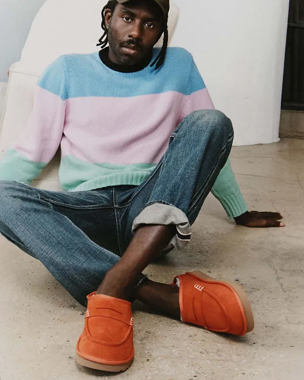 A man sitting on the floor wearing our UGG JW Anderson Loafer.