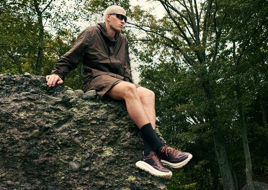 Modèle masculin assis sur un rocher tout en portant la Mafate Speed 4.