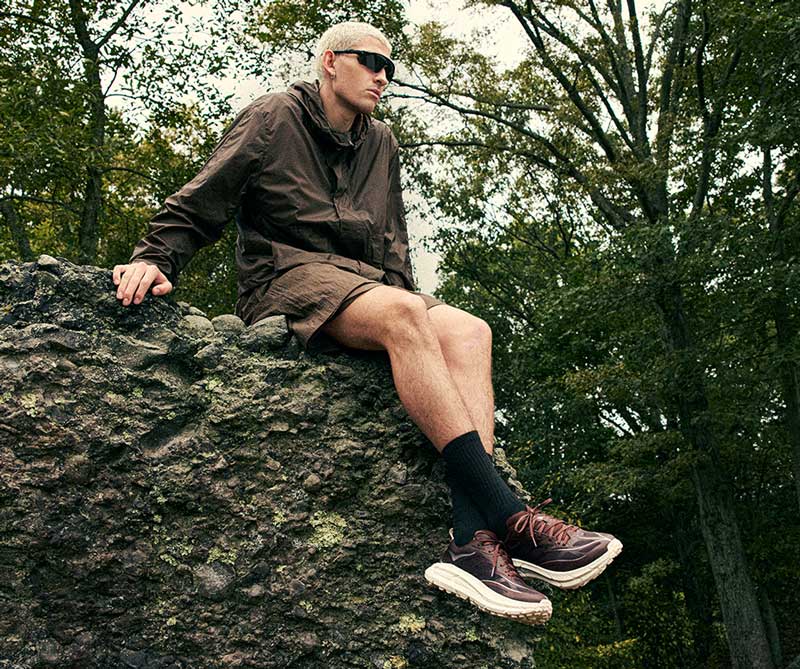 Modèle masculin assis sur un rocher tout en portant la Mafate Speed 4.