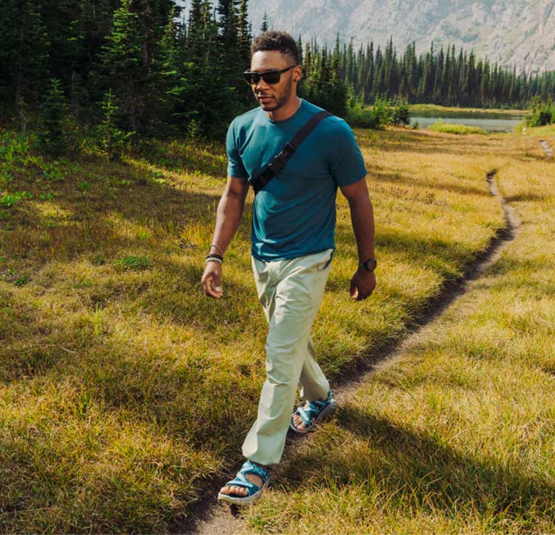 Mannequin faisant de la randonnée au bord d’un lac de montagne portant les sandales Inifini Hike.
