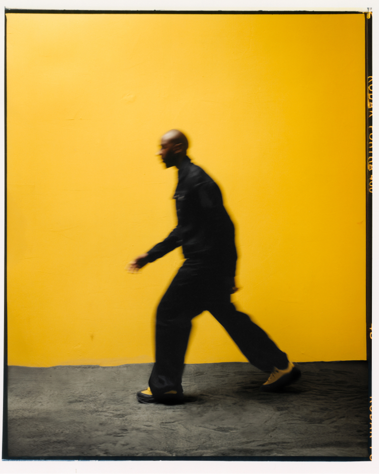 Spencer Badu marchant avec des chaussures Spencer Badu x Hoka.
