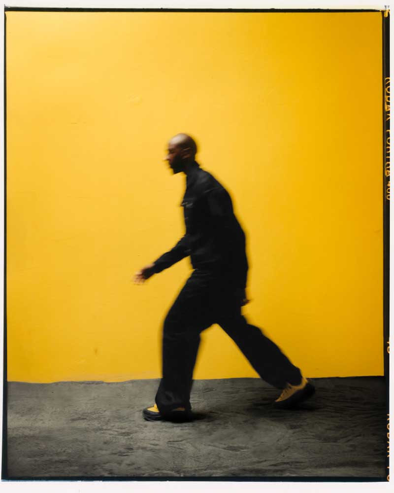 Spencer Badu marchant avec des chaussures Spencer Badu x Hoka.