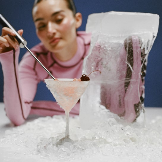Une personne mixant une boisson fraîche à côté d’un bloc de glace.