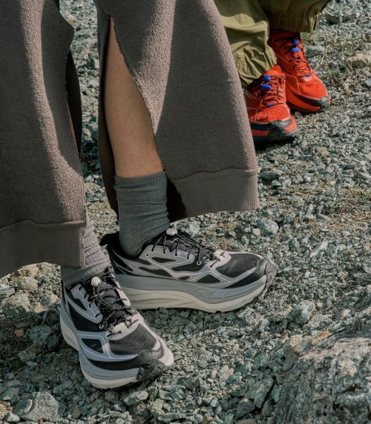 Plan rapproché sur les pieds d’une personne portant des chaussures HOKA Stinson ONE7.