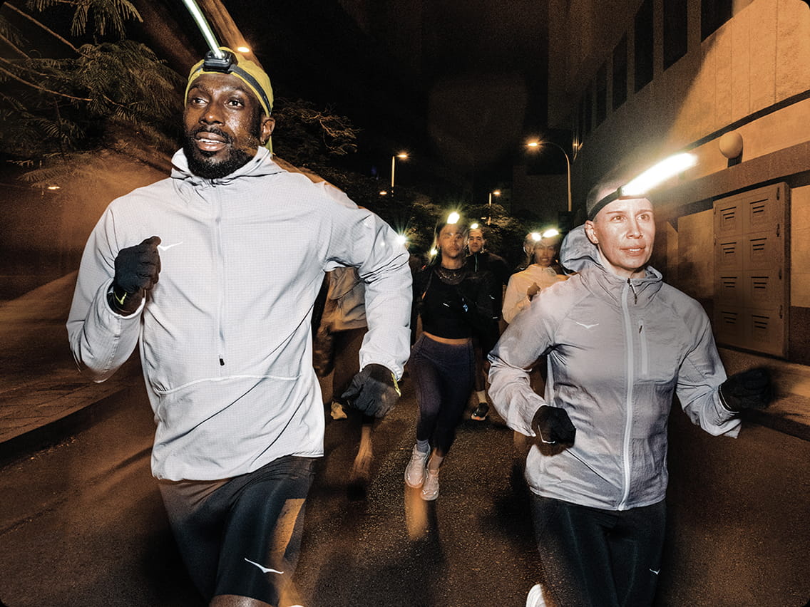 Deux personnes courant la nuit en tenue HOKA.