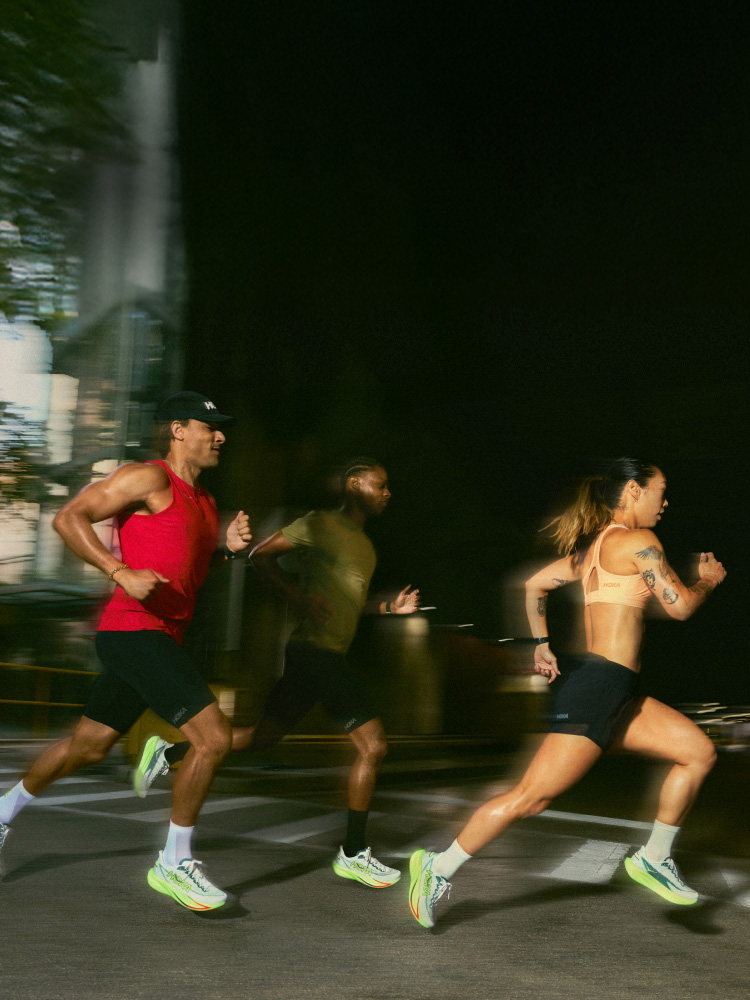 Three people running on a road.