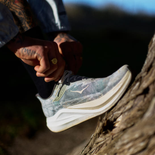 Photo de John Elliott en train de nouer ses chaussures HOKA.