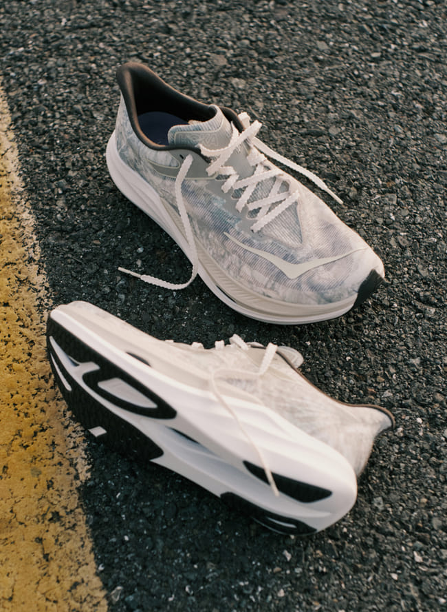 Photo d'une paire de chaussures issues de la collaboration entre HOKA et John Elliott.