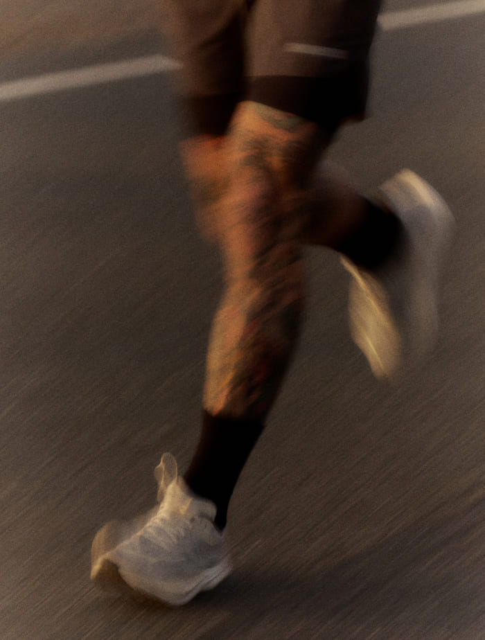 Gros plan des jambes de John Elliott en train de courir.