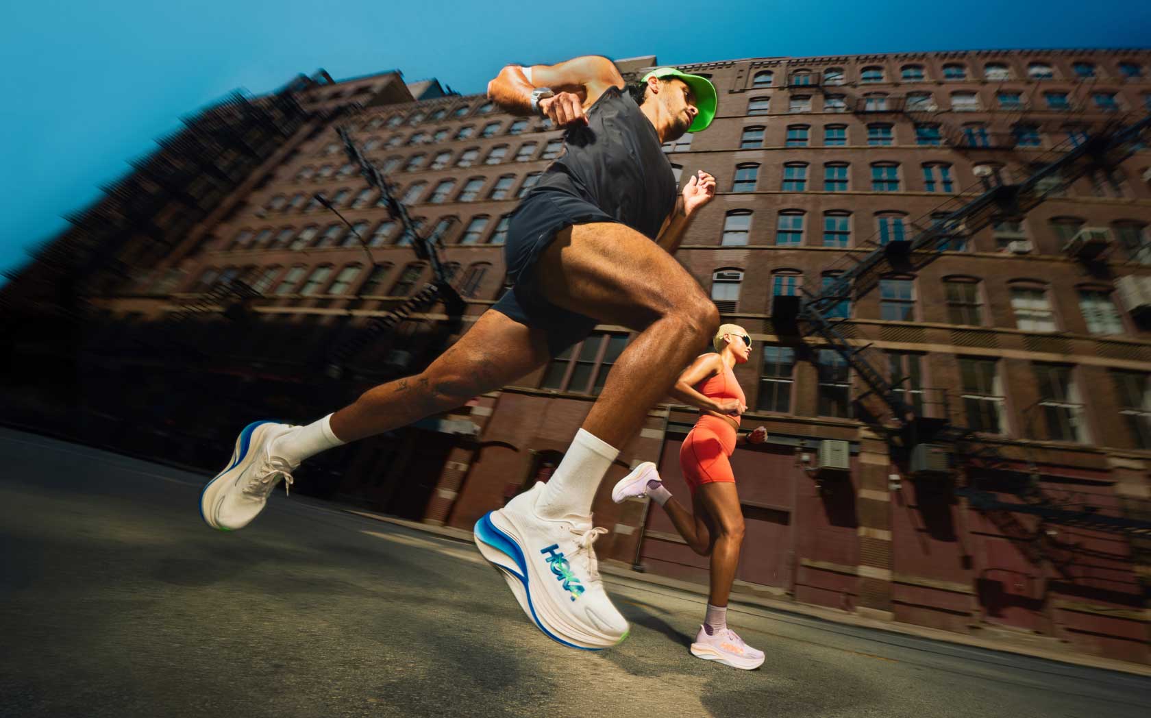 2 coureurs courant en ville, prise photo en angle vers le haut.