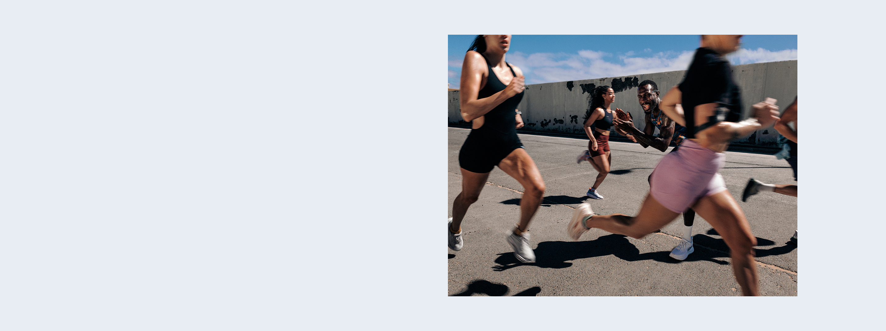 Un groupe diversifié d’athlètes courant vite lors d’une séance d’entraînement en plein air sur une surface asphaltée.