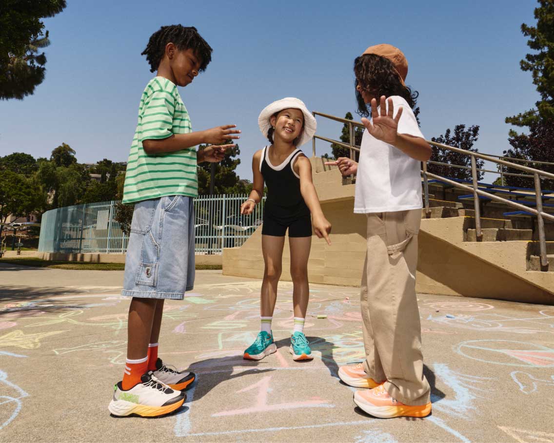 Des enfants jouant à la marelle en portant des chaussures HOKA.