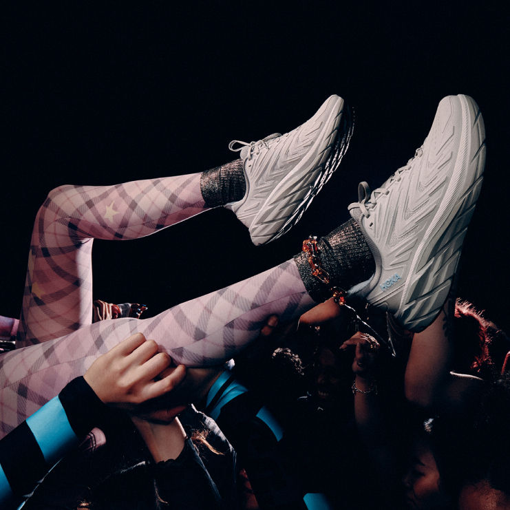 Close up of a person legs wearing HOKA UTL shoes.