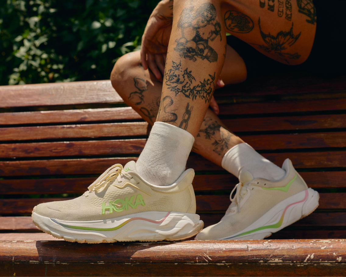 femme assise sur un banc portant des chaussures HOKA.