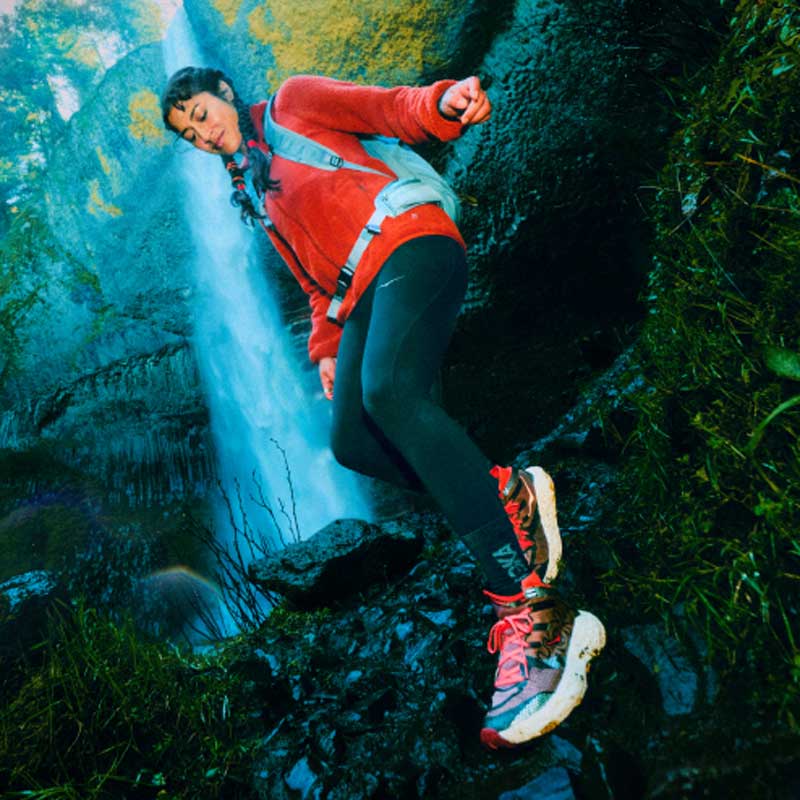 Femme courant dans une forêt tropicale portant la chaussure Speedgoat 7 Hike GTX.