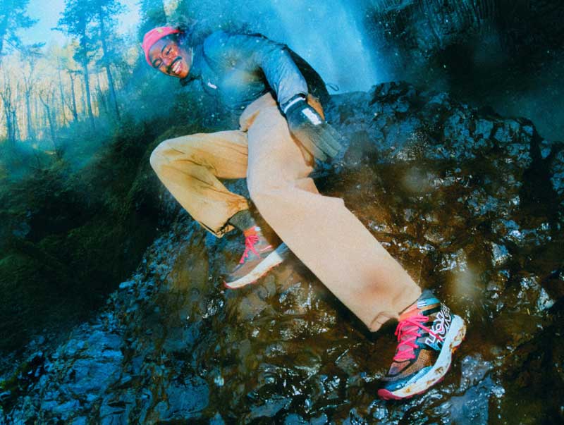 Male model sitting on rock wearing the Speedgoat 7 Hike GTX shoe.