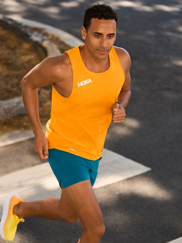 Man running on the road wearing HOKA clothing.
