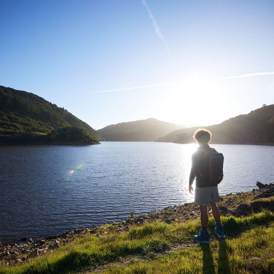 Better for the planet. Person standing near a lake.
